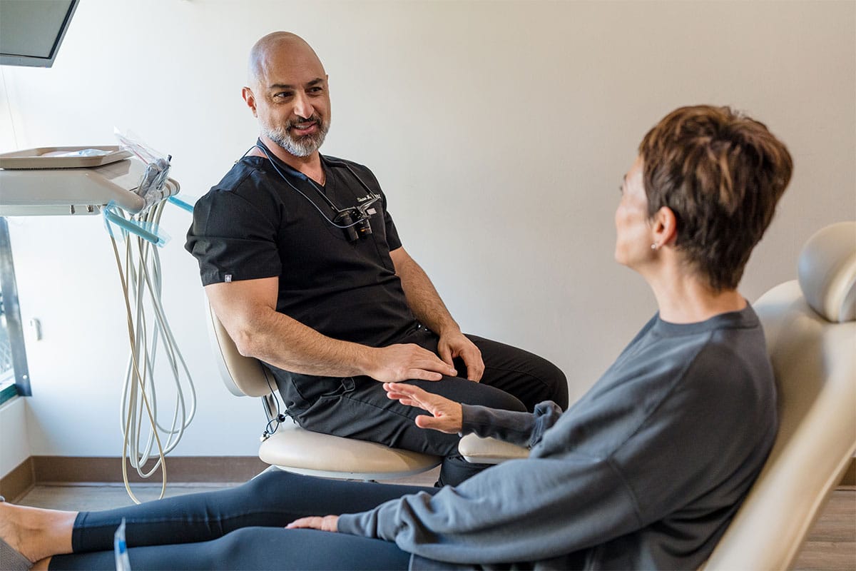 The dentist discussing dental implants in Encino with a patient.